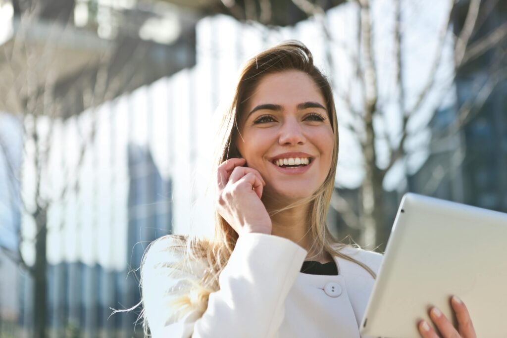 pexels-photo-789822-789822 Confident businesswoman using her tablet and phone, smiling outdoors in sunlight.